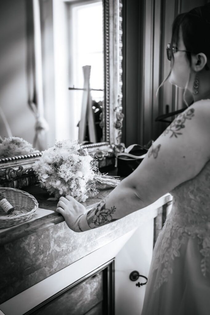 La mariée devant le miroir en train de se préparer pour la cérémonie