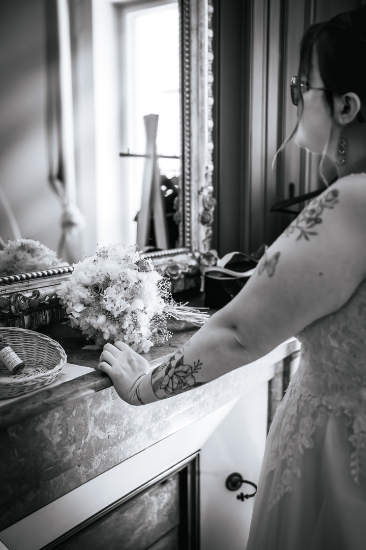 La photographie de mariage en noir & blanc Détail en noir et blanc d’une mariée avec son bouquet pendant les préparatifs