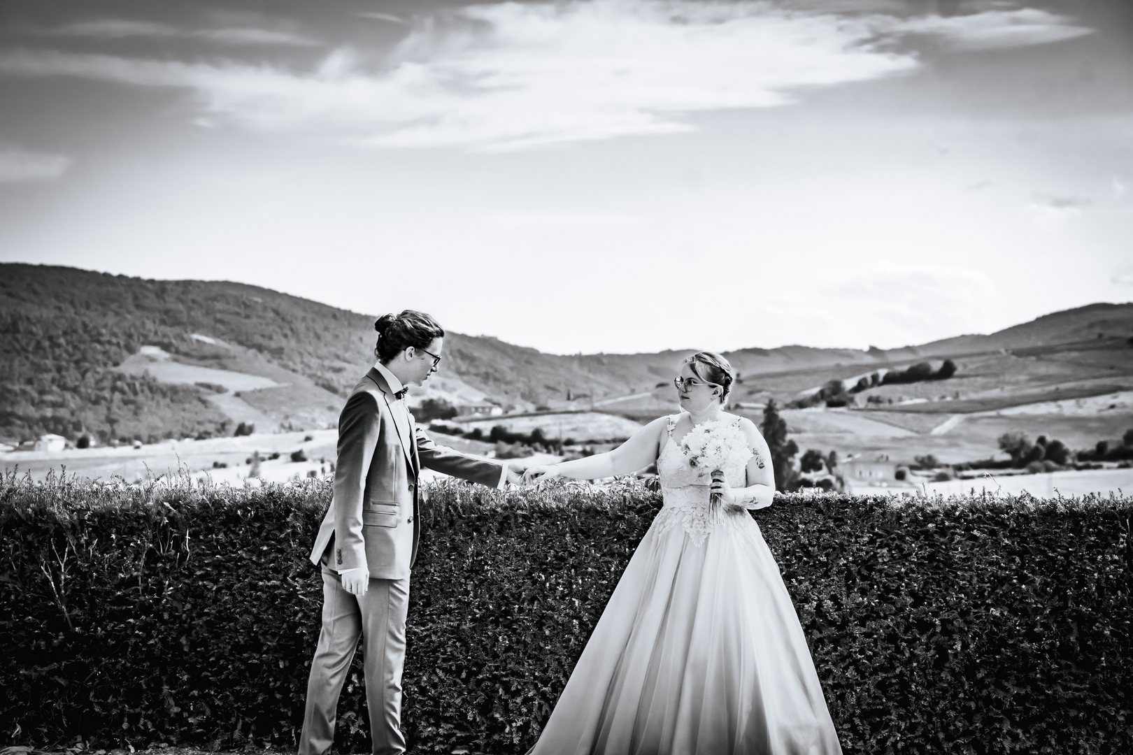 La photographie de mariage en noir & blanc Photo de couple en noir et blanc des mariés dans un paysage de campagne