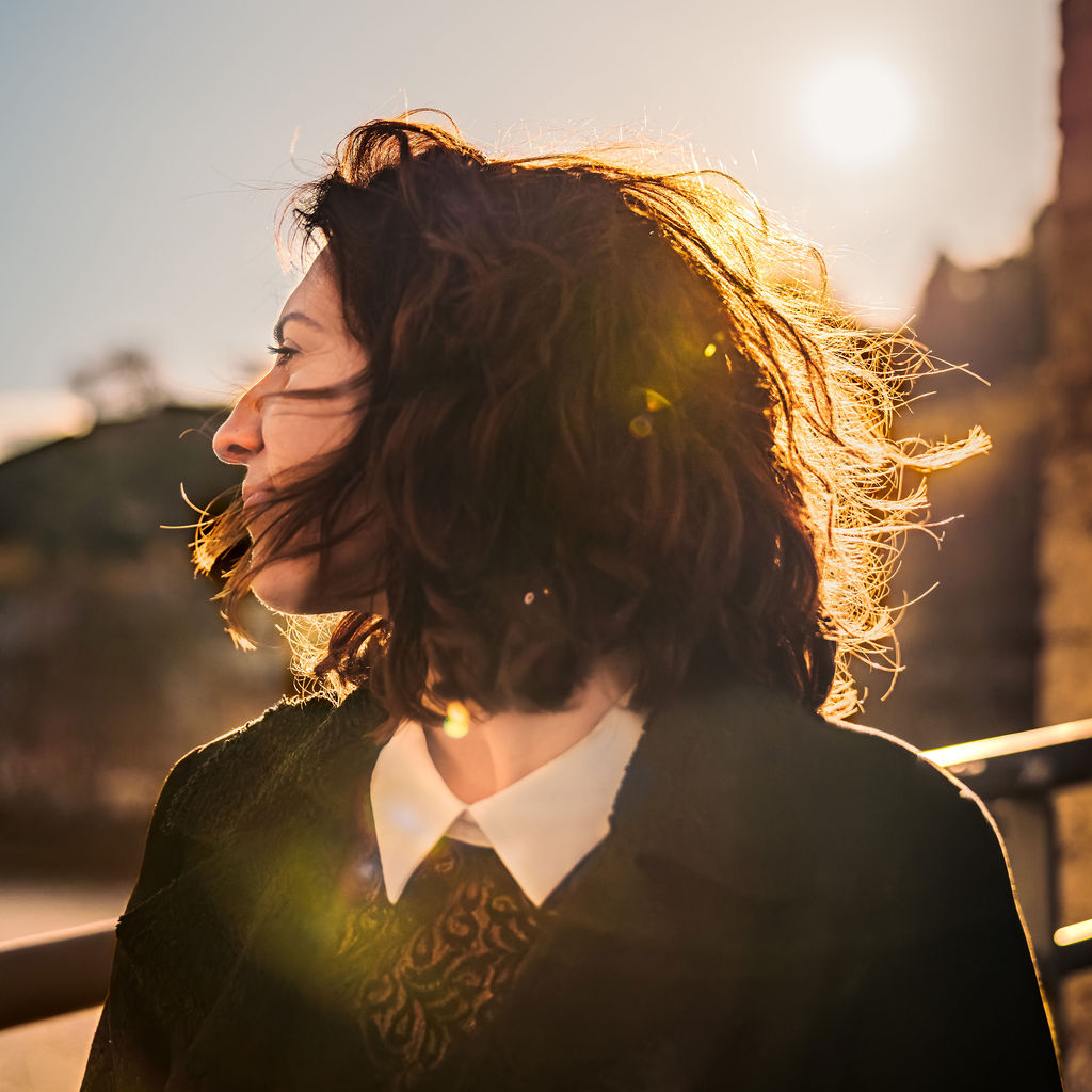 Femme photographiée en extérieur avec le soleil en arrière-plan