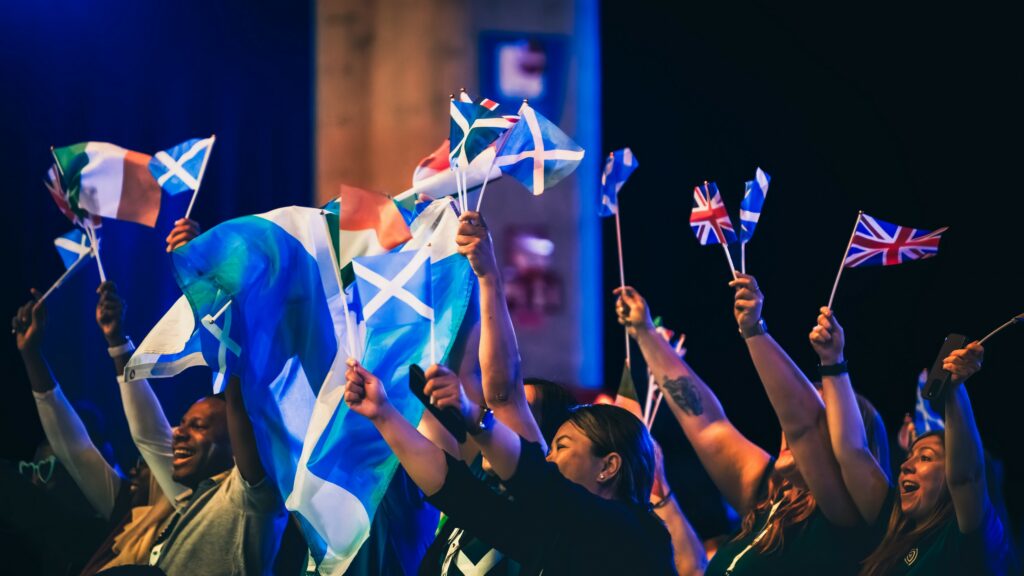 Participants brandissant des drapeaux lors d’un moment festif d’un évènement associatif